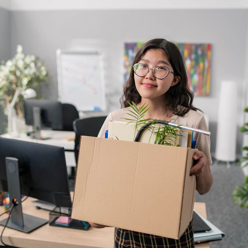 employee quitting and holding cardboard box walking out of office