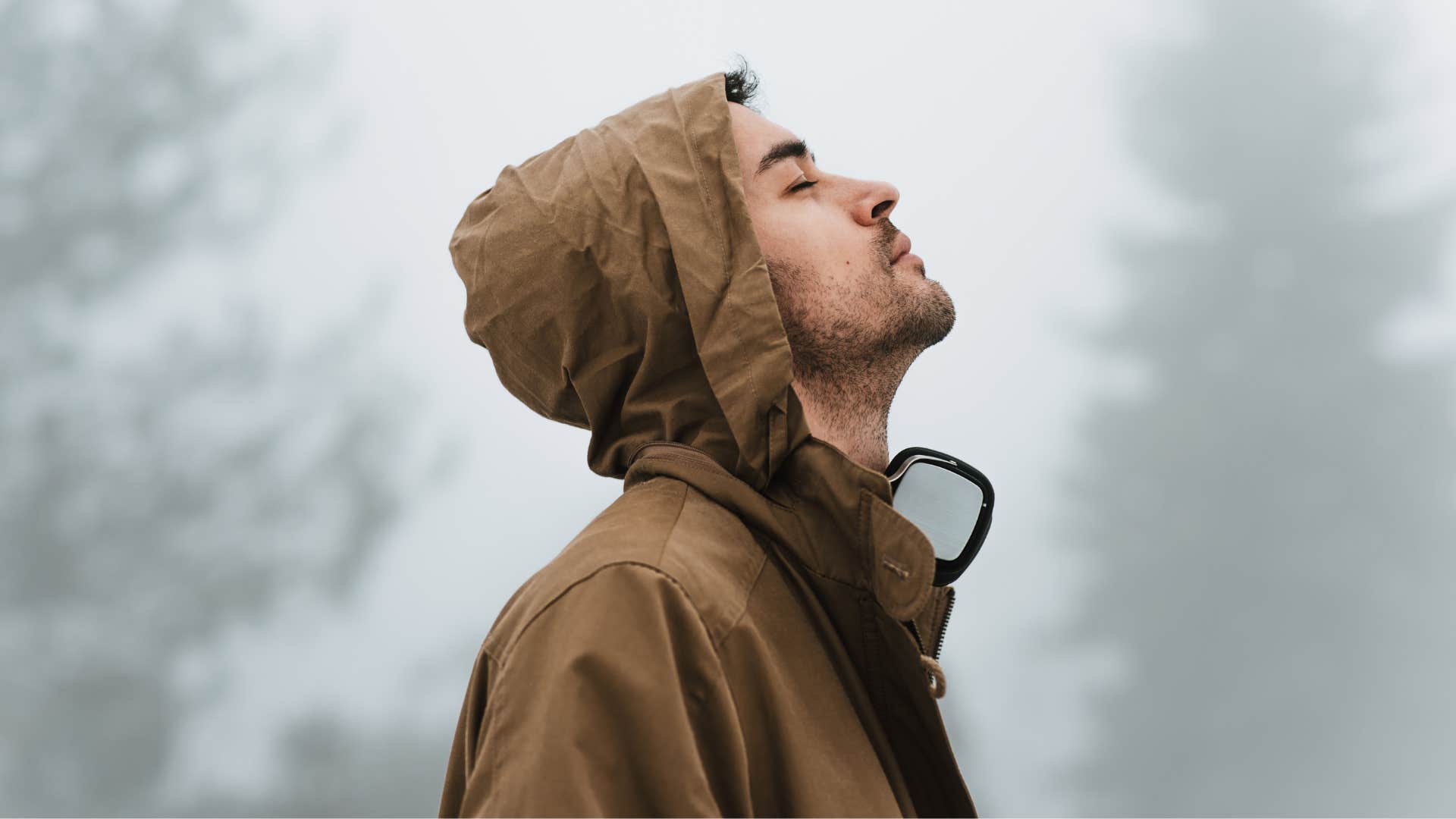 Humble man who appreciates what he has looking up in the forest 