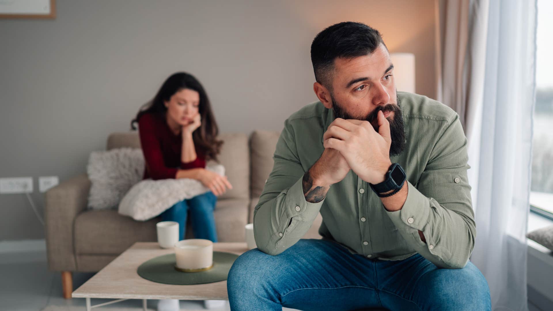 upset man sitting away from wife after argument