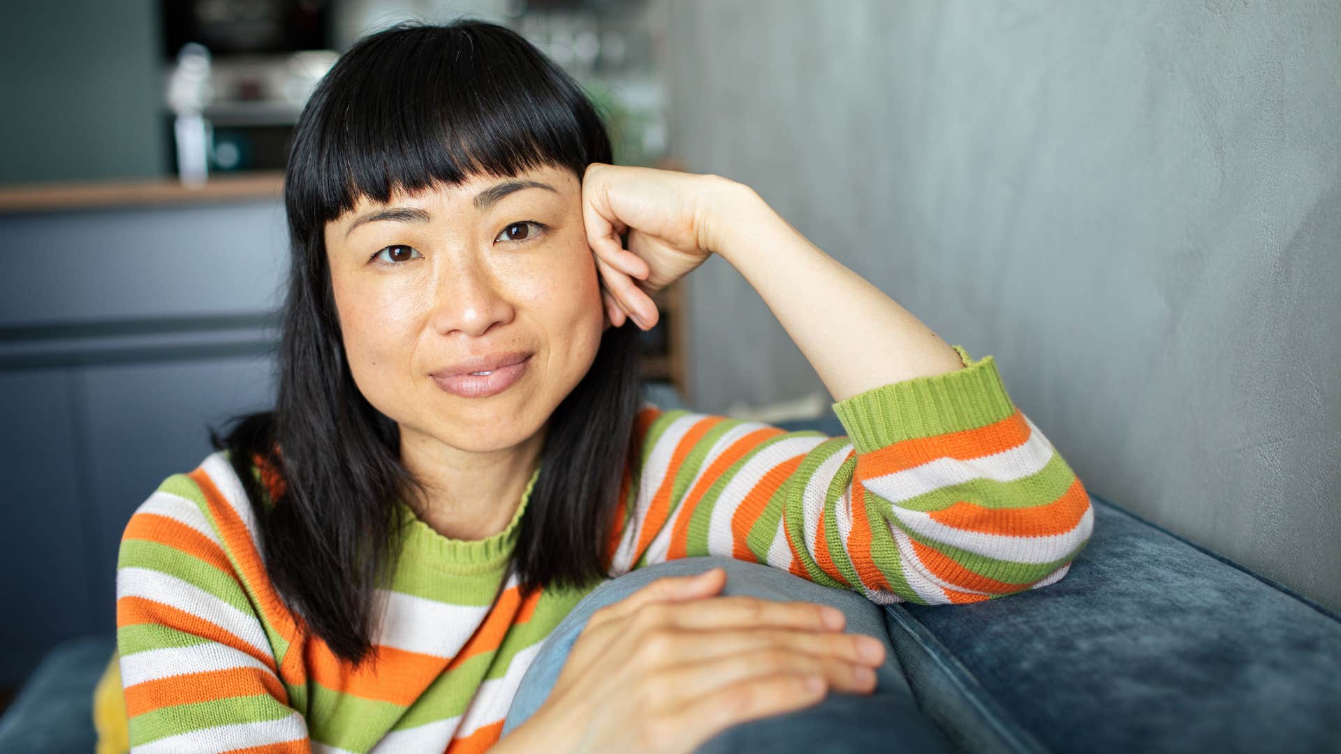 woman who appreciates structure sitting alone smiling