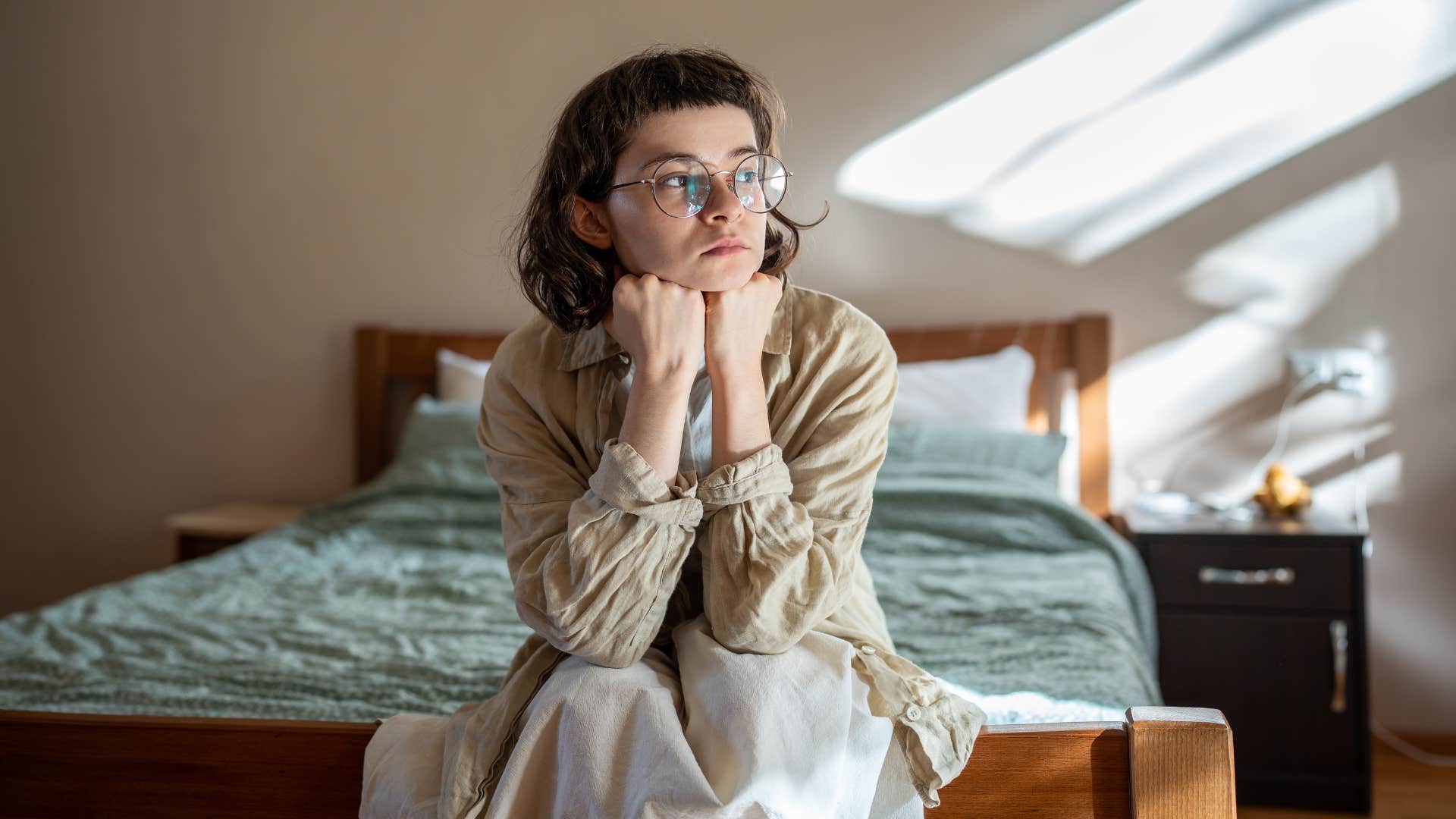 sensitive young person sitting in bed