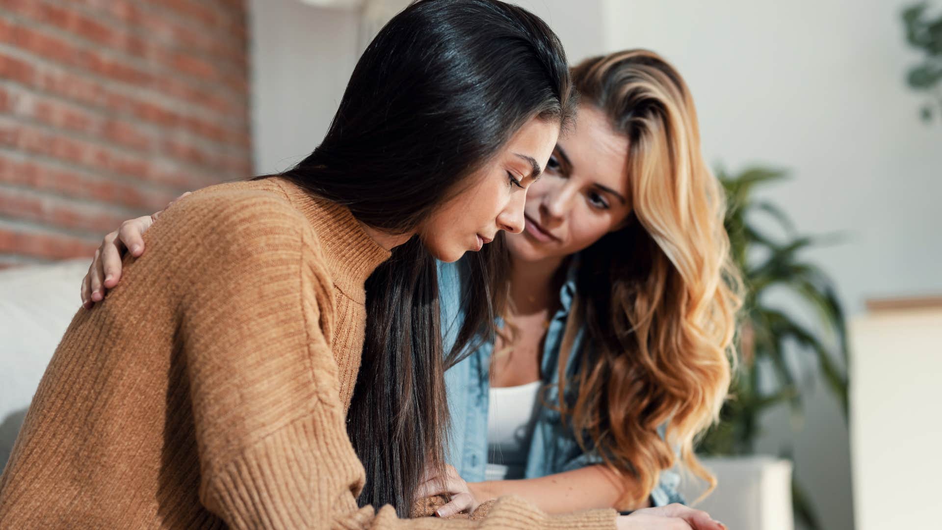 thoughtful empathetic woman comforting friend
