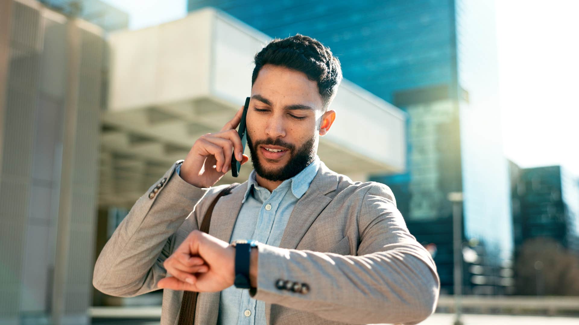 deeply irritated man looking at watch noticing friend is late
