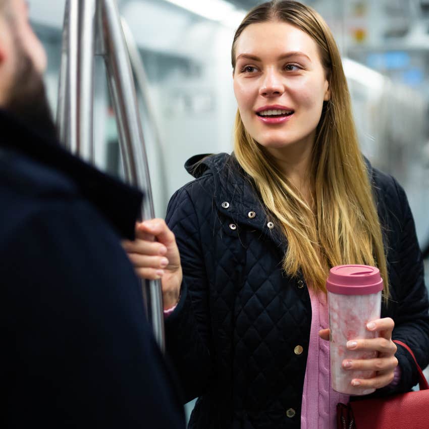 curious woman smiling at a stranger on a subway