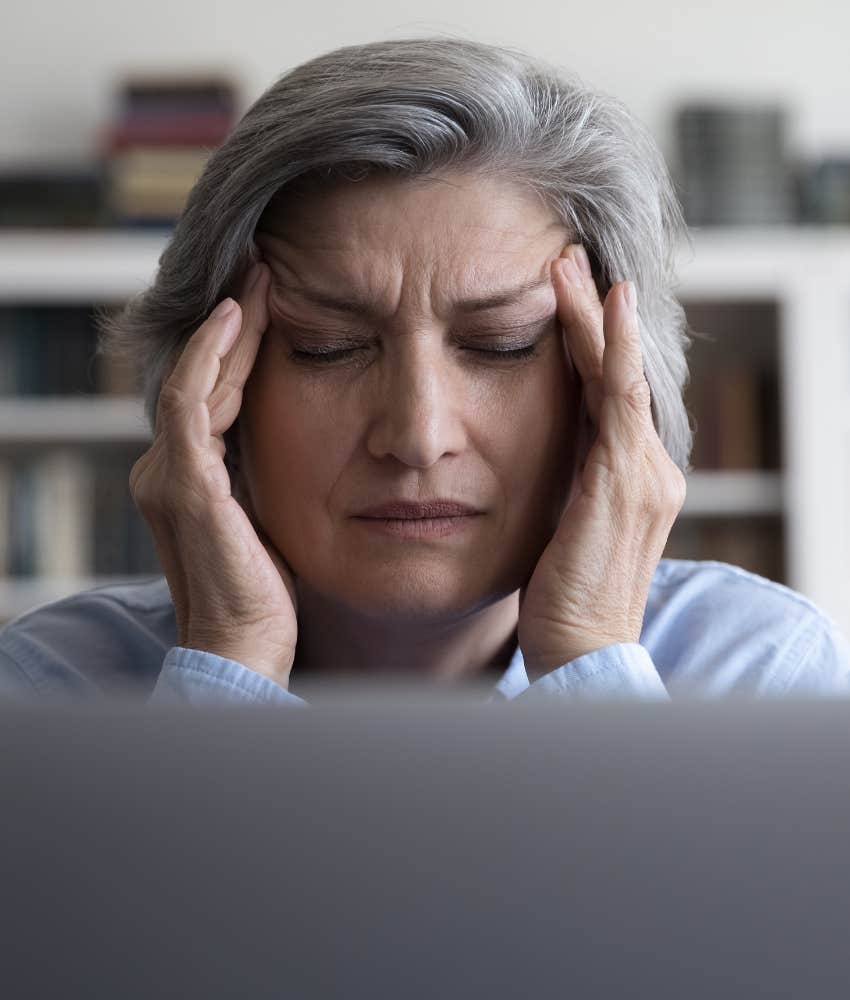 Tenser person at work touches forehead showing headache