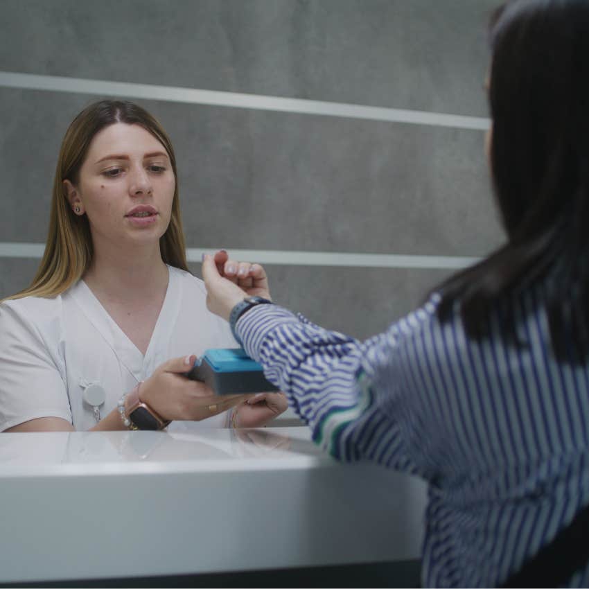 Woman paying for unexpected medical bills at the doctor