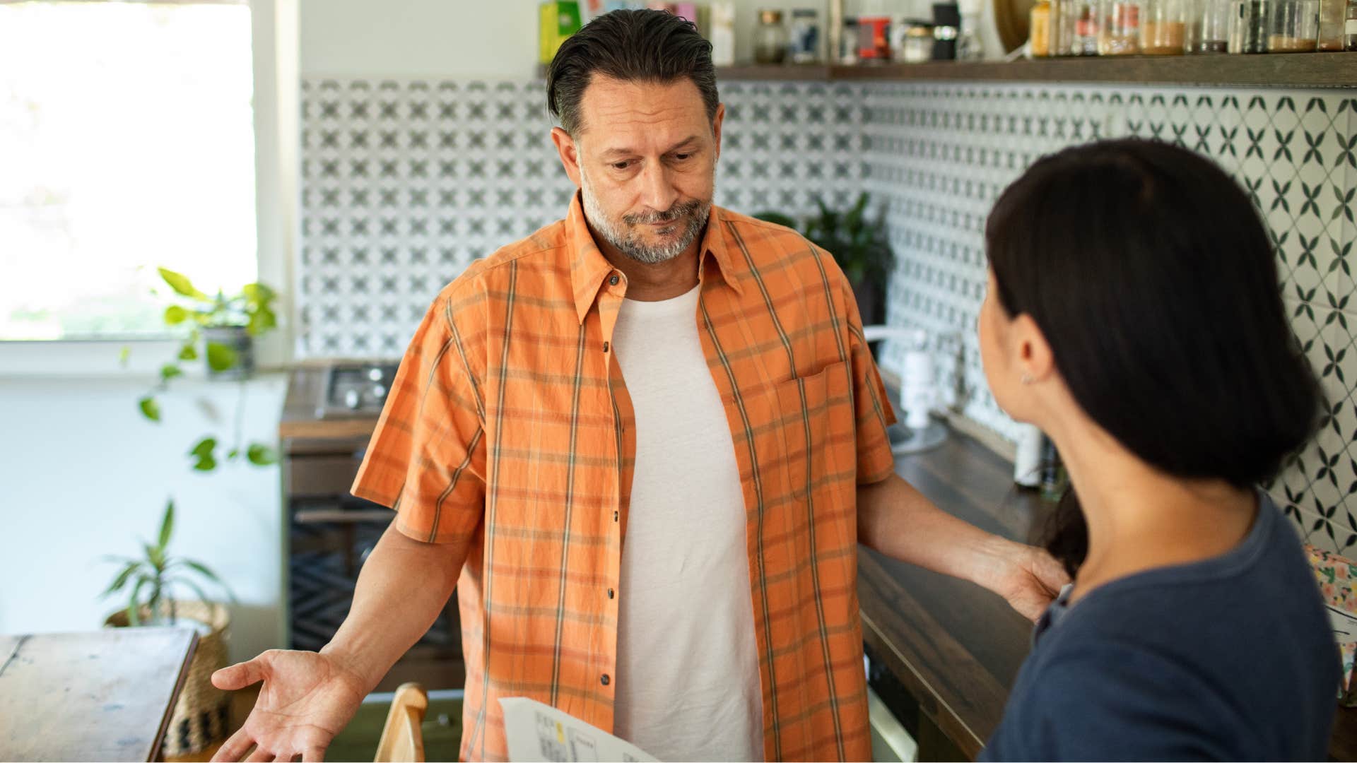 annoyed man saying sorry but... to his partner appearing uneducated to her