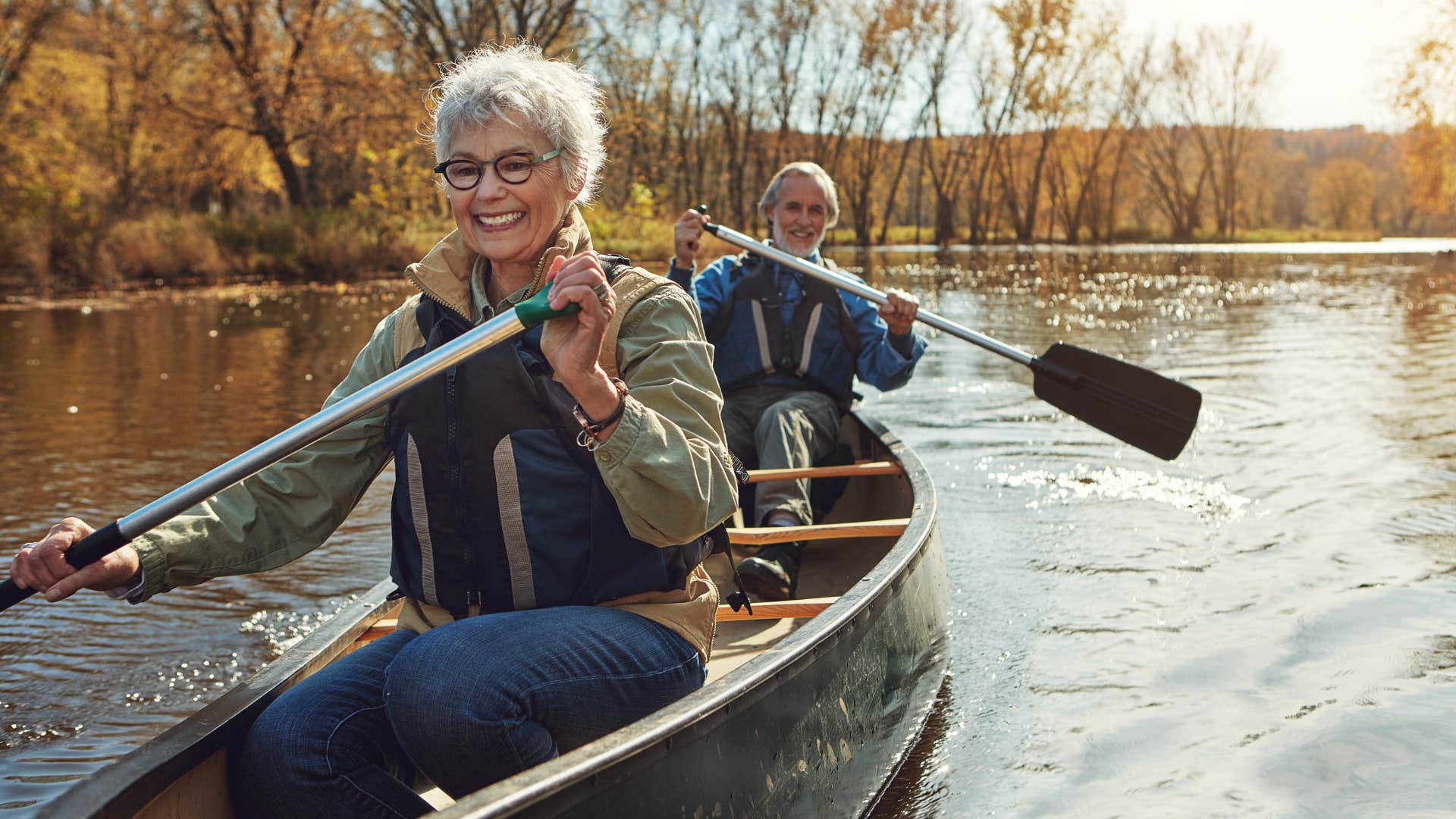Older couple row canoe showing habit of believing in self