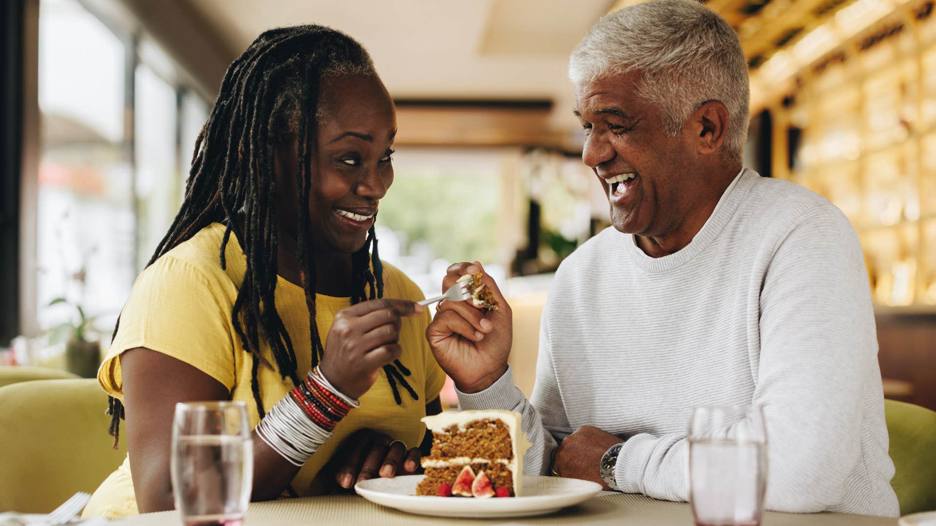 Happy couple share cake showing habit of thinking positively