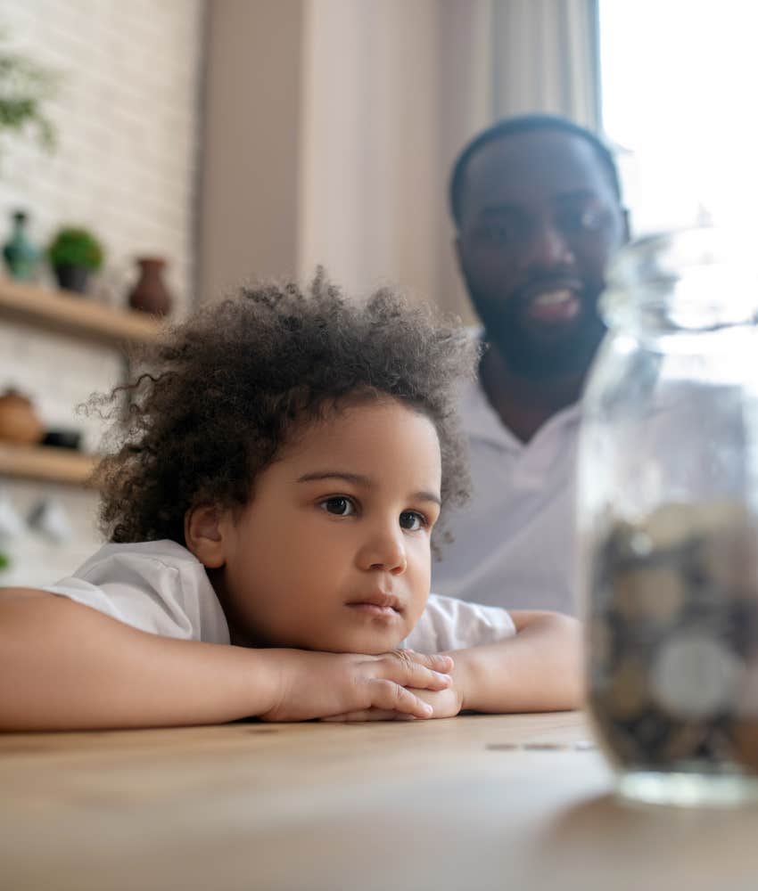 Pleased parent and focused kid with money jar showing fast change