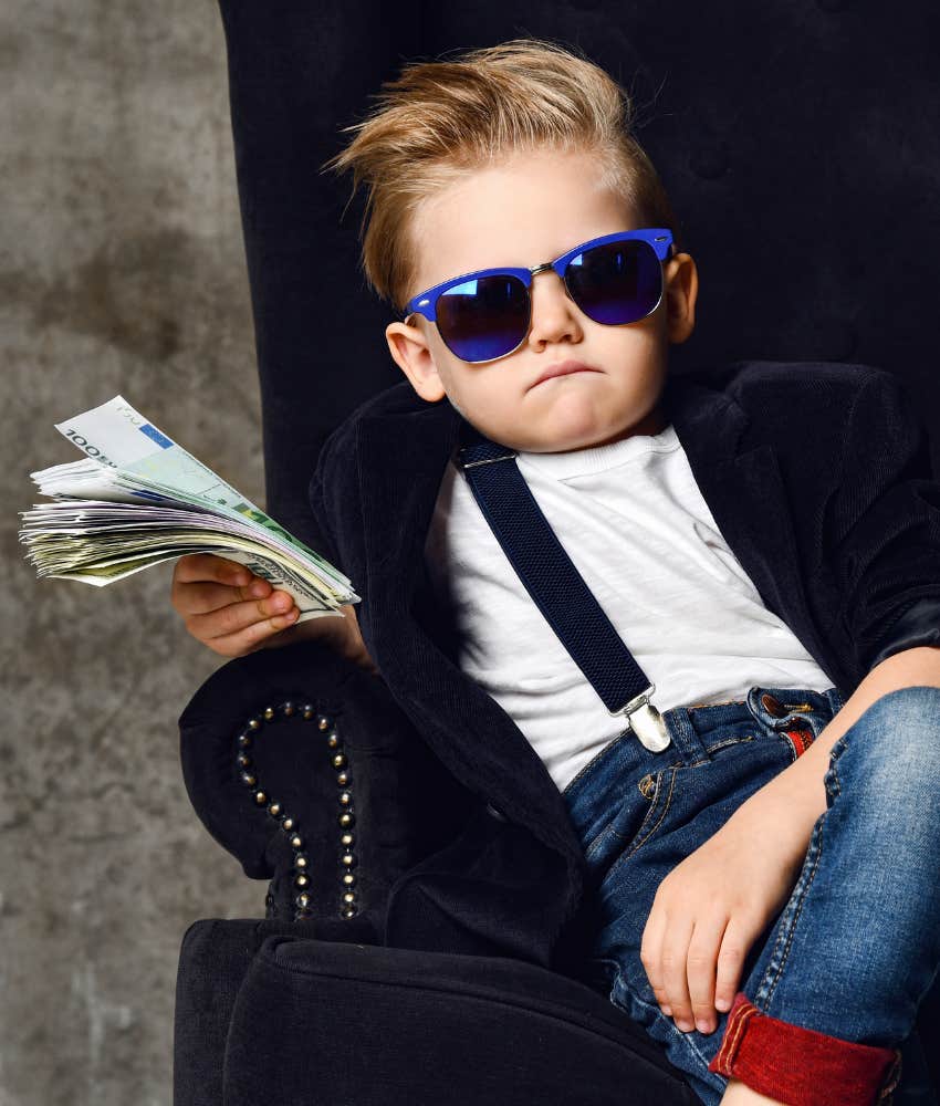 precocious kids with sunglass and stack of cash showing they are spoiled