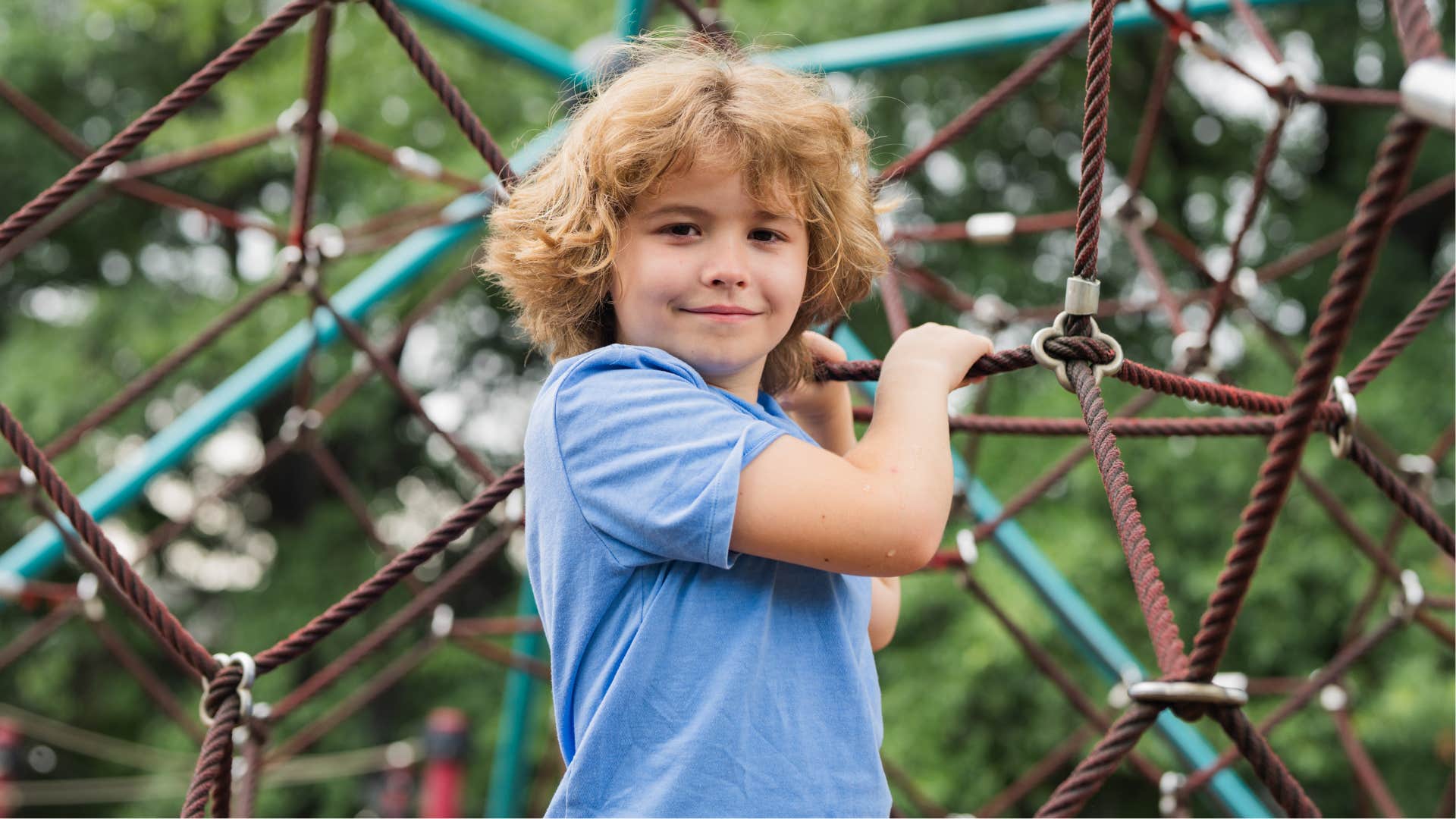 Active boy climbs rope structure