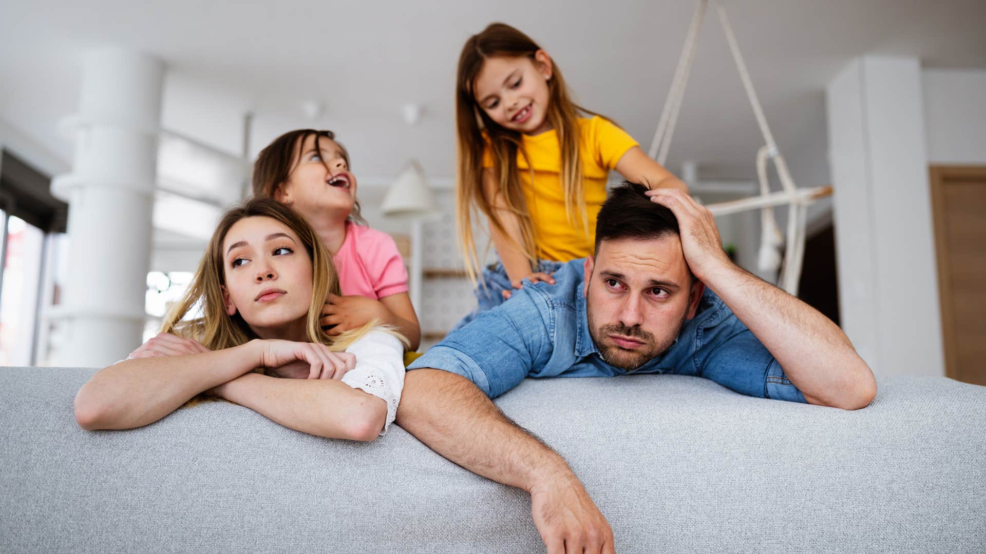 stressed parents sacrificing their independence while kids play on them
