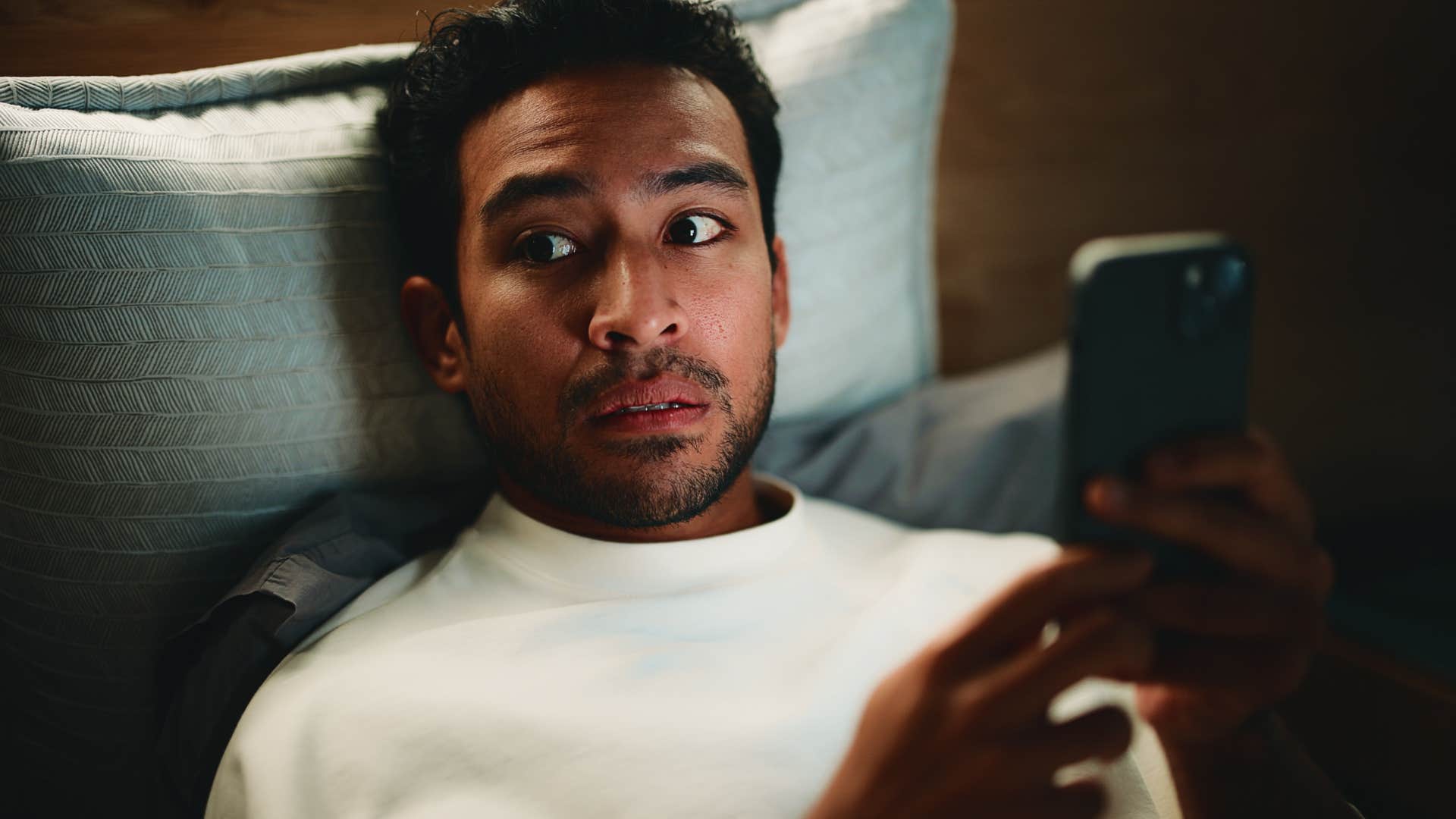man watching intense movies before bed looking paranoid