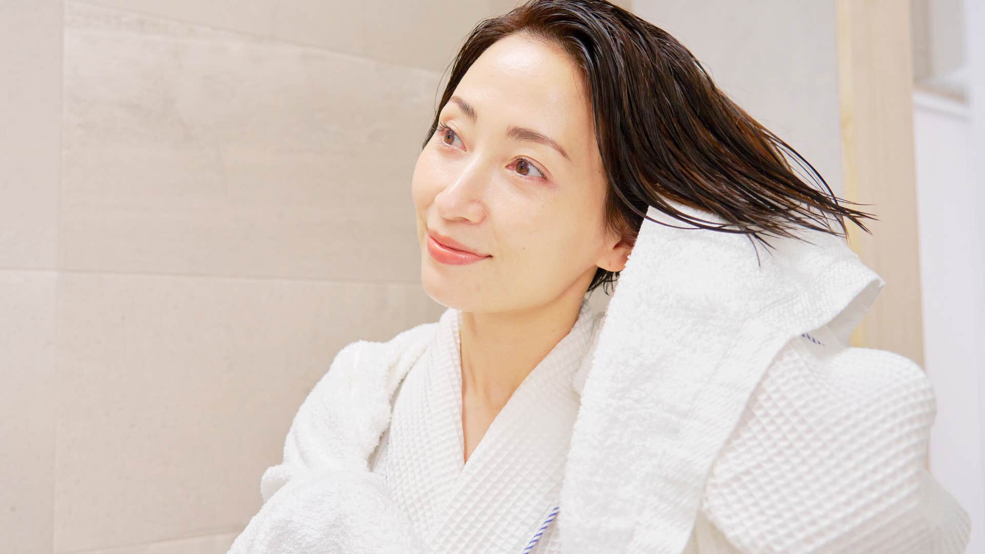 woman reusing bath towels in her home after shower