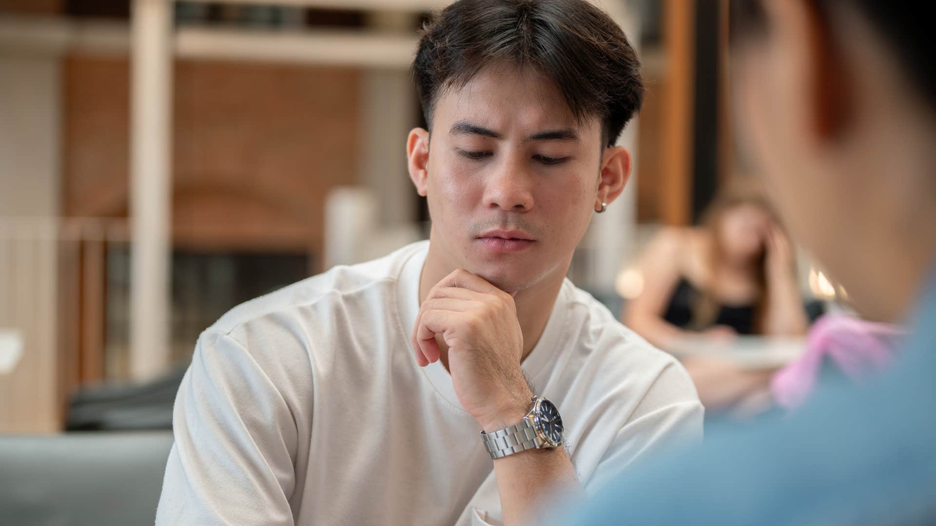 introverted man in conversation not being easily peer pressured by friend
