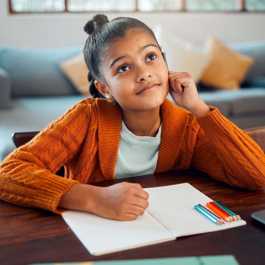 resourceful little girl writing at home