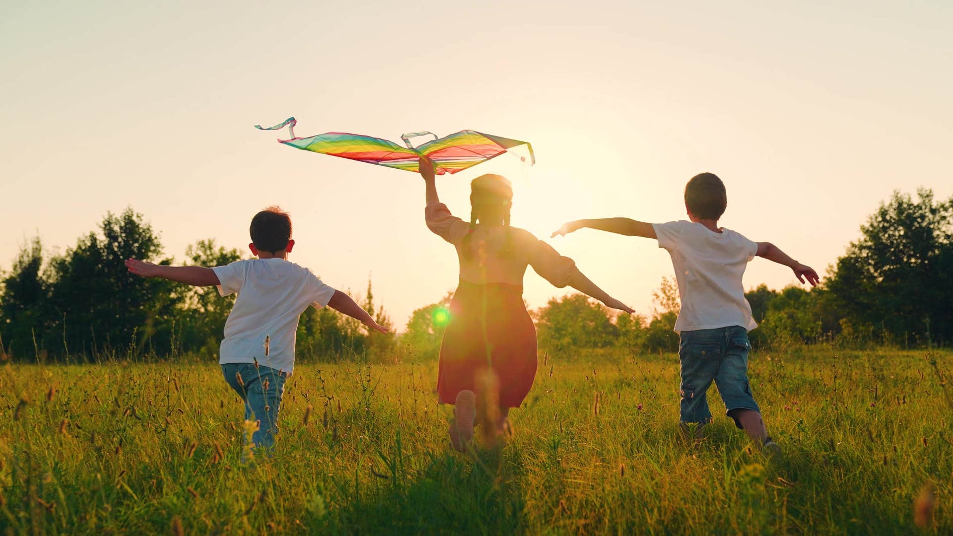 Kids with kite run outside showing why kindness matters