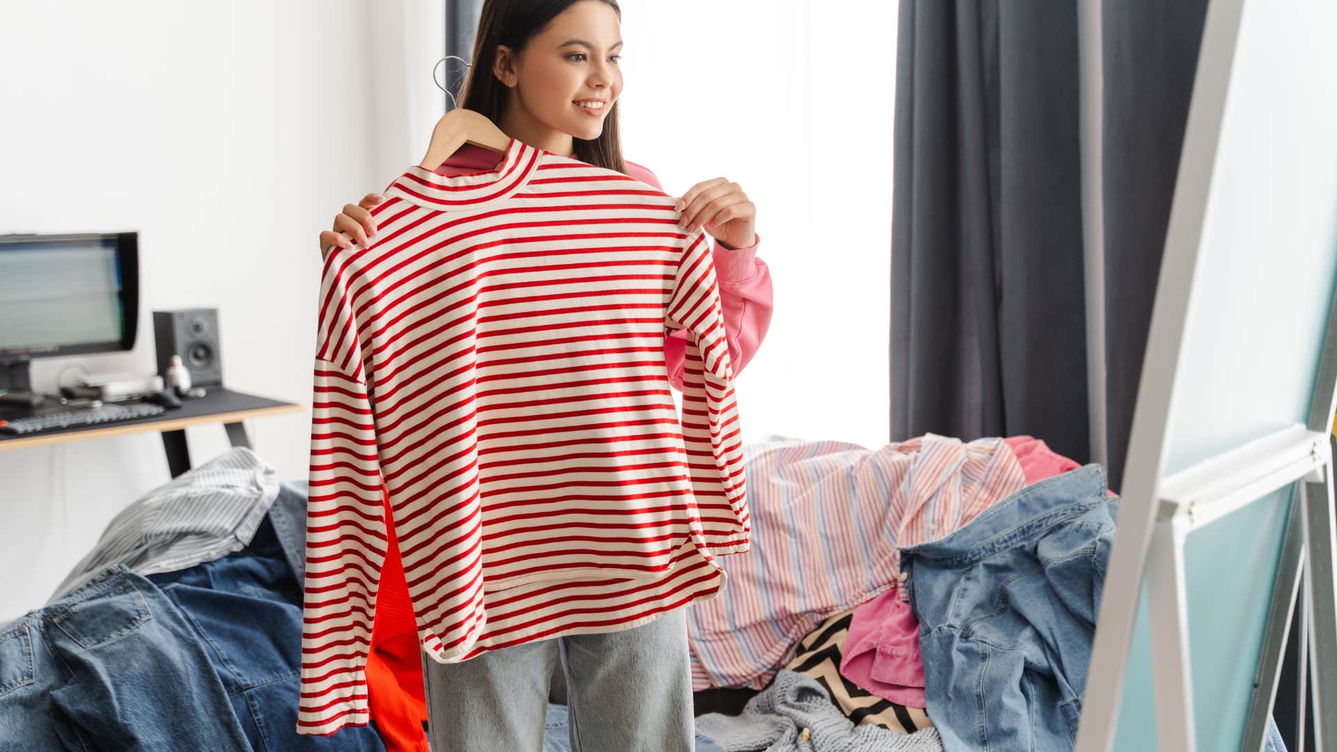 teenage girl trying on shirt