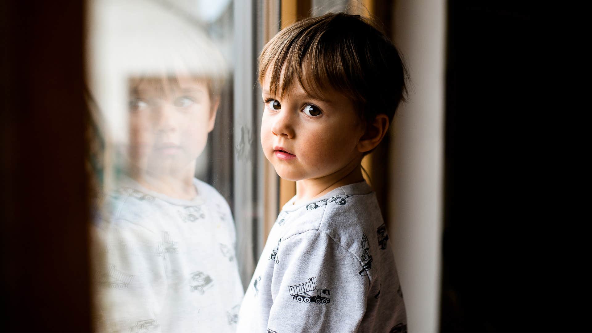 very young boy feeling invisible standing alone
