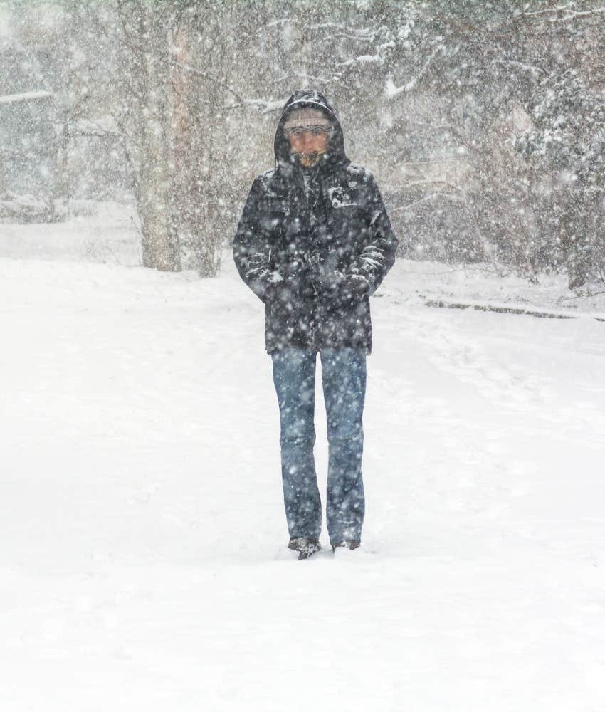 distant man partially obscured by snowstorm showing reinforced isolation