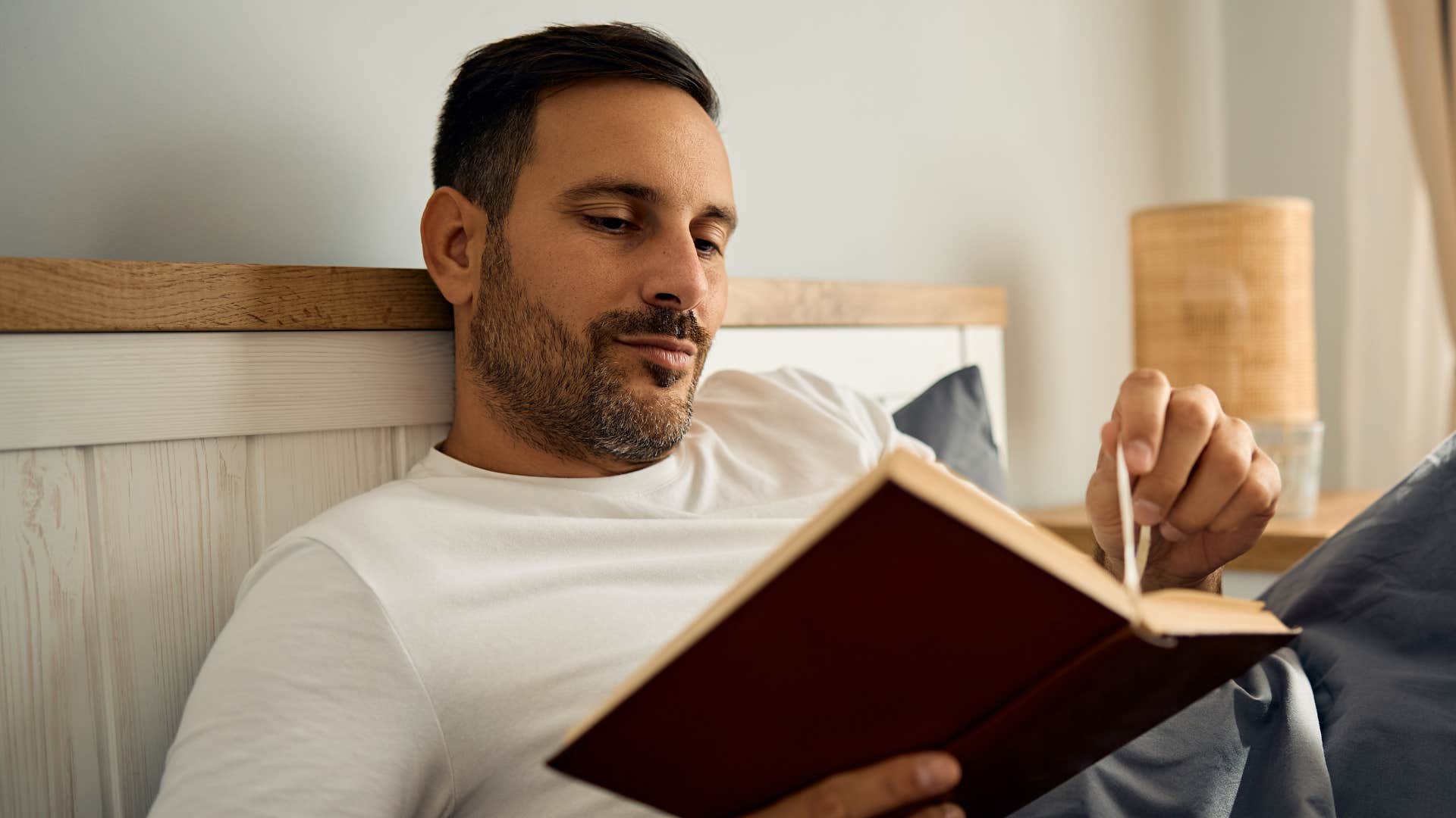 Lonely man with quiet traits reading at home 