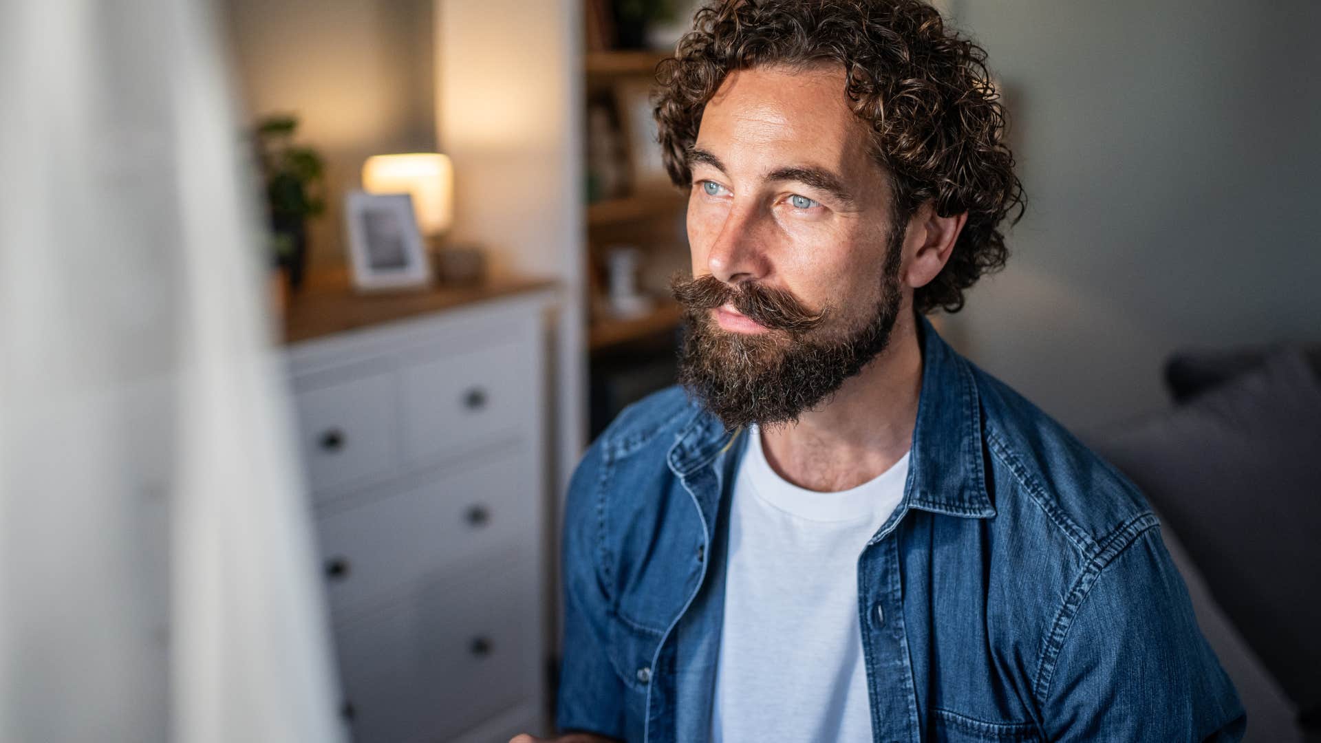 Man who prefers quiet alone time looking out a window.