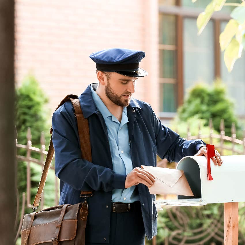 mail carrier delivering letter to mailbox