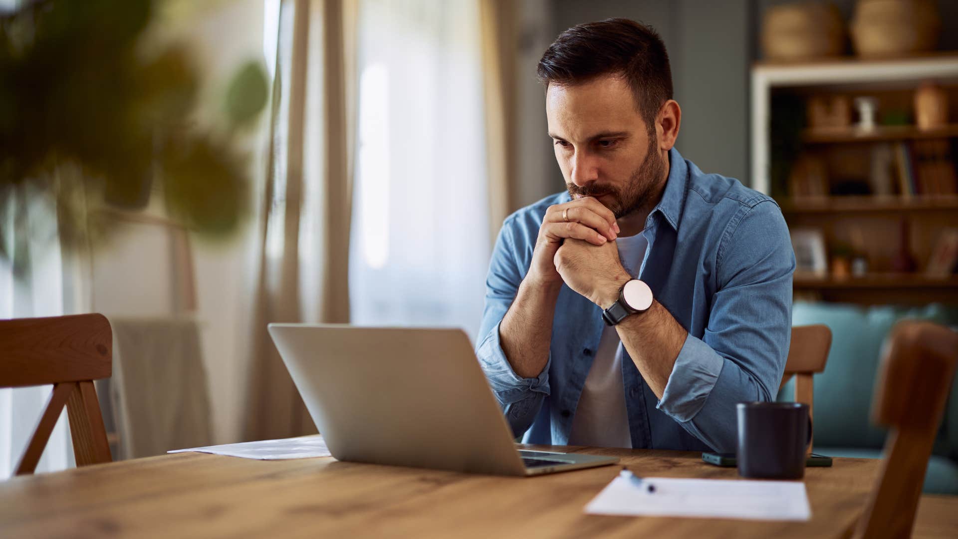 highly cautious man looking at social media on his computer