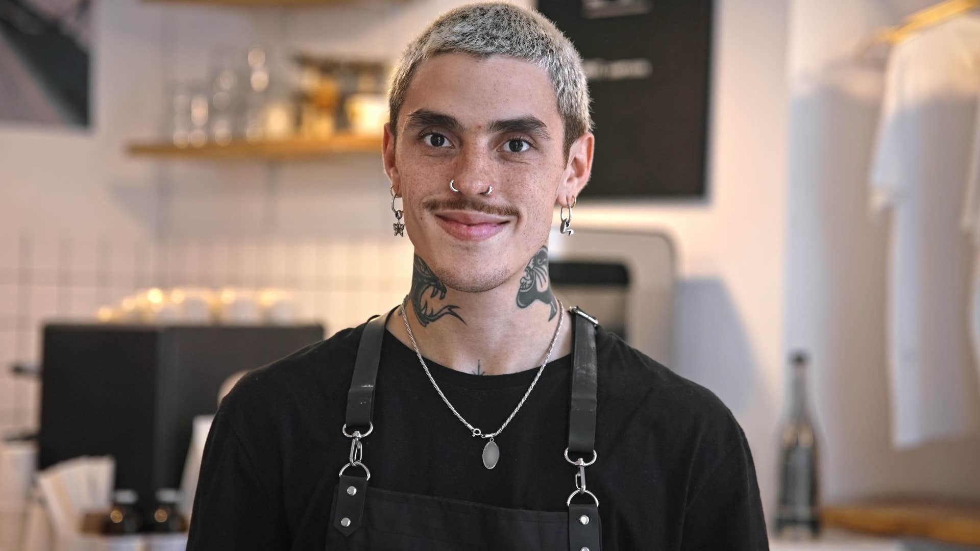 creative man with tattoos smiling at work
