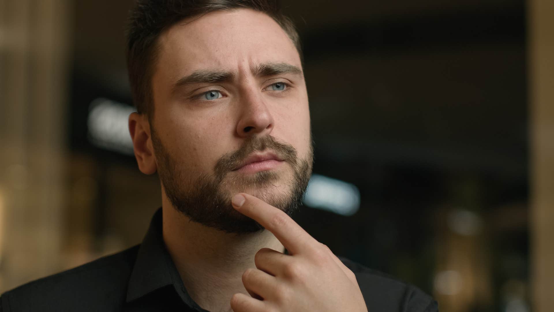 emotionally consistent man thinking with finger on chin