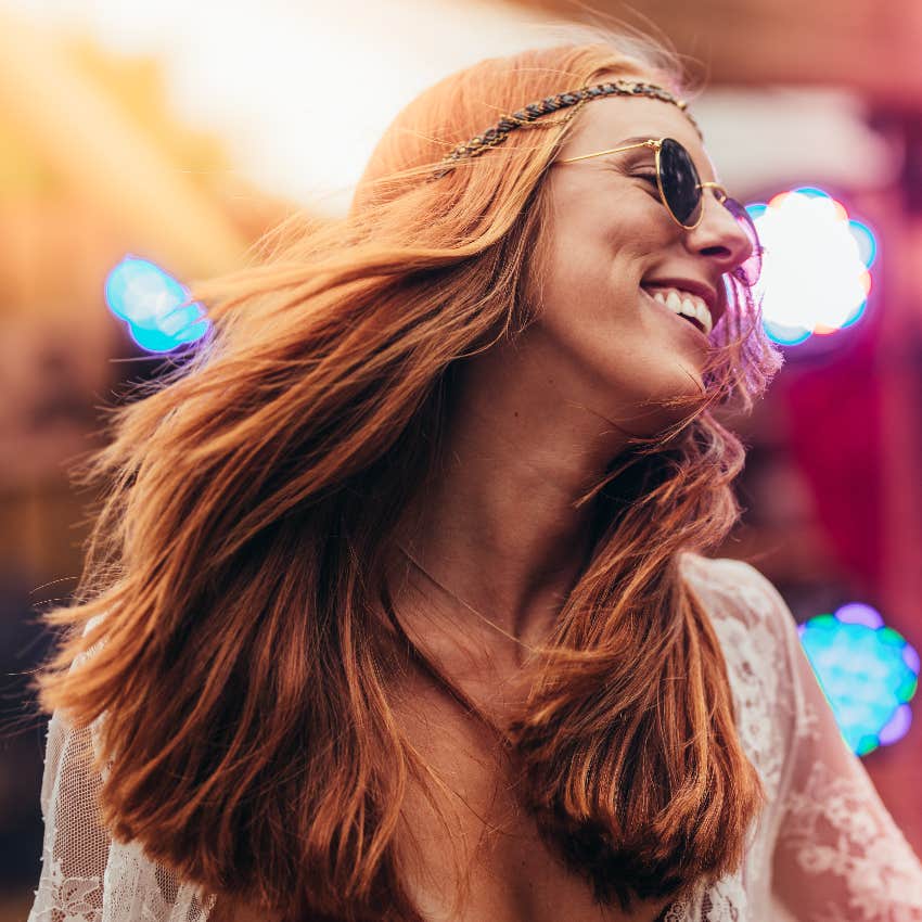 happy woman over forty dancing at music festival