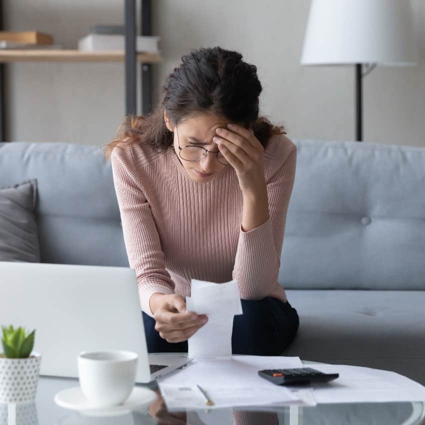 woman stressed looking at bills americans more broke than they realize