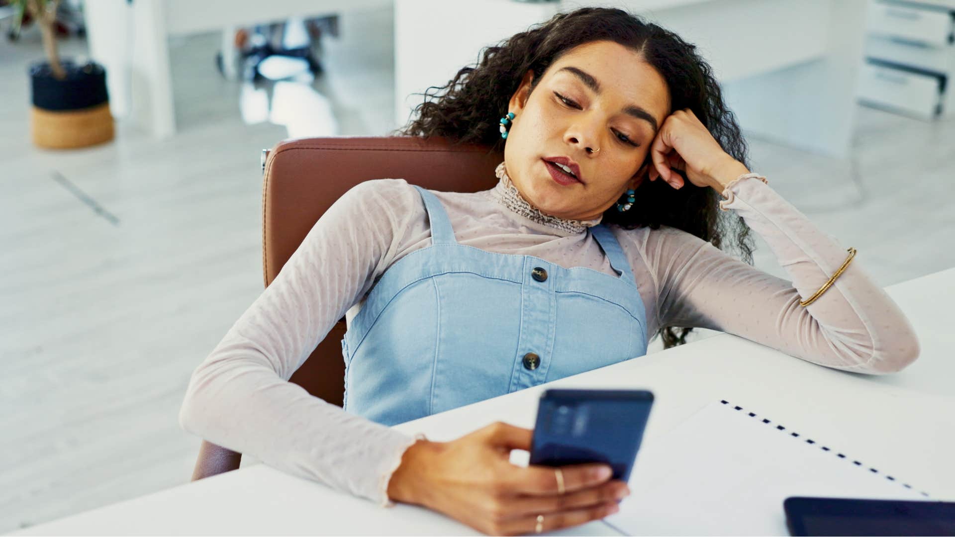nonchalant Gen Z woman looking bored at work