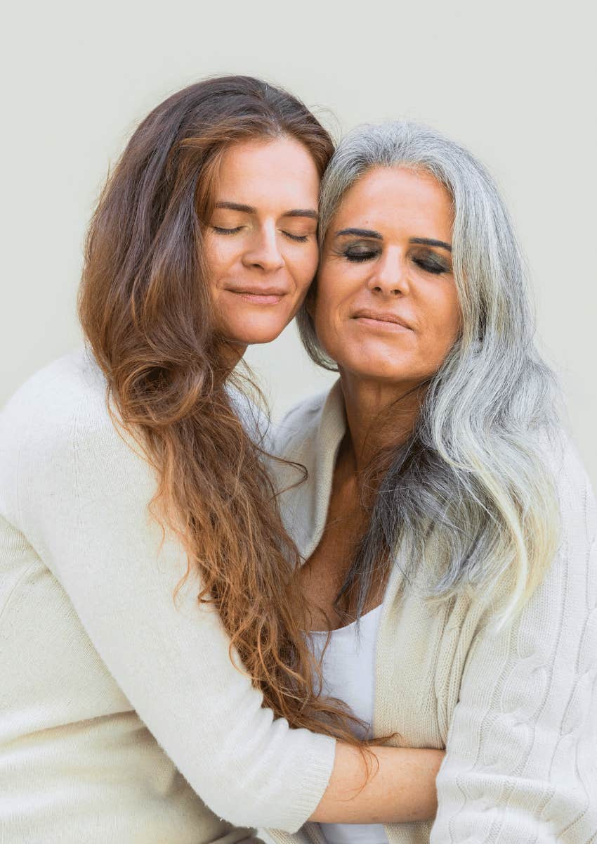 mother and adult daughter hugging each other close