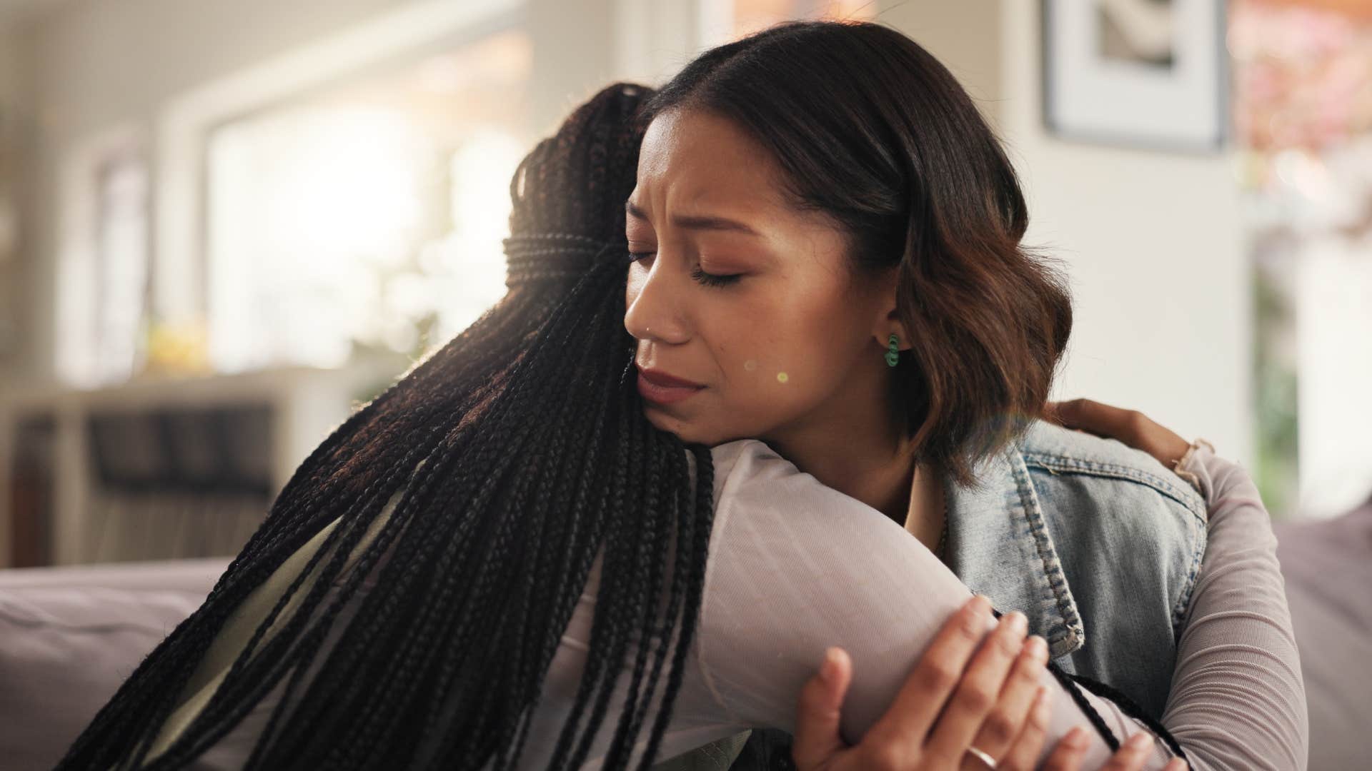 friends hugging one another as woman with braids says let's stop pretending everything is okay
