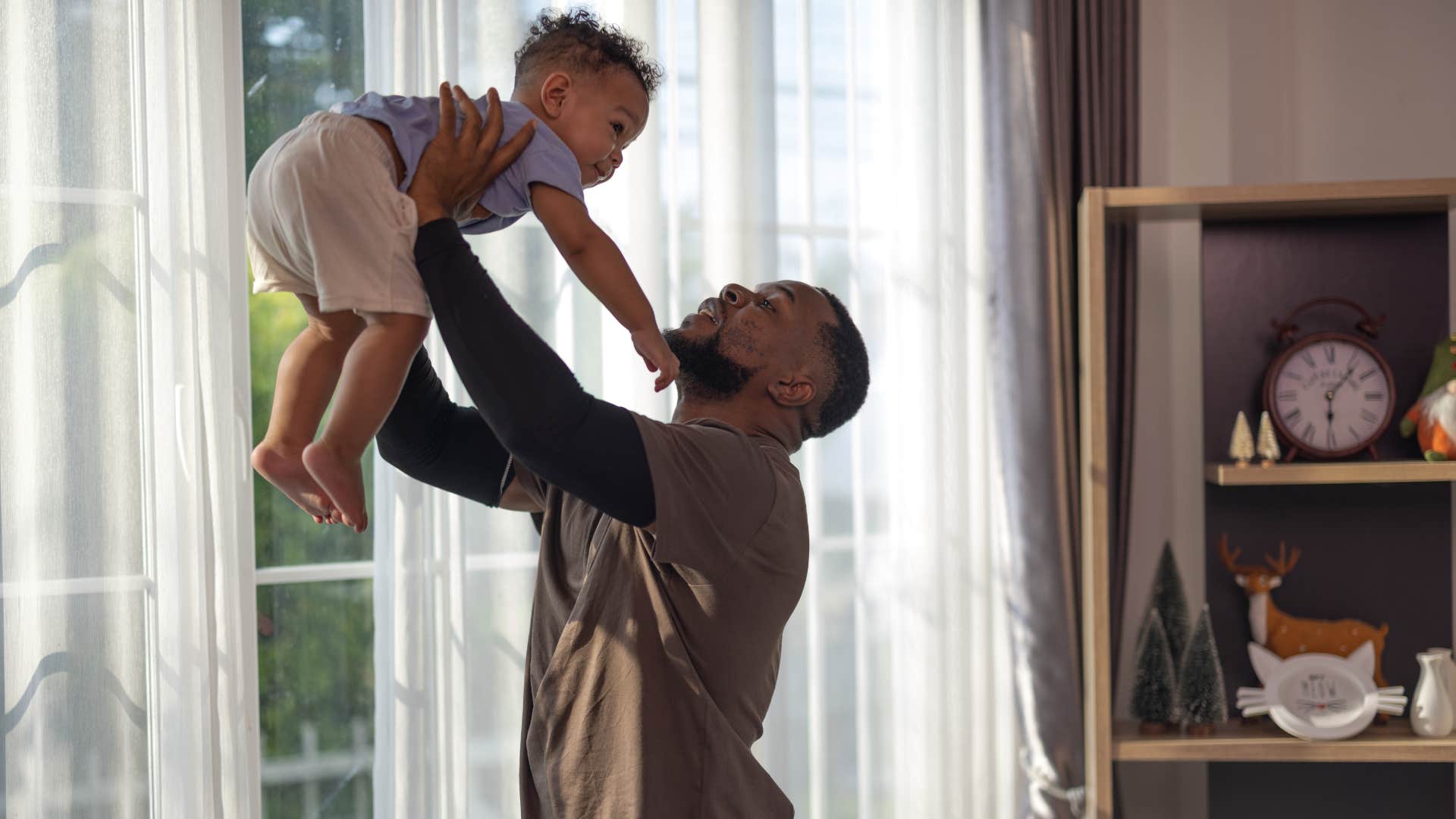 dad holding up baby monitoring them 24/7