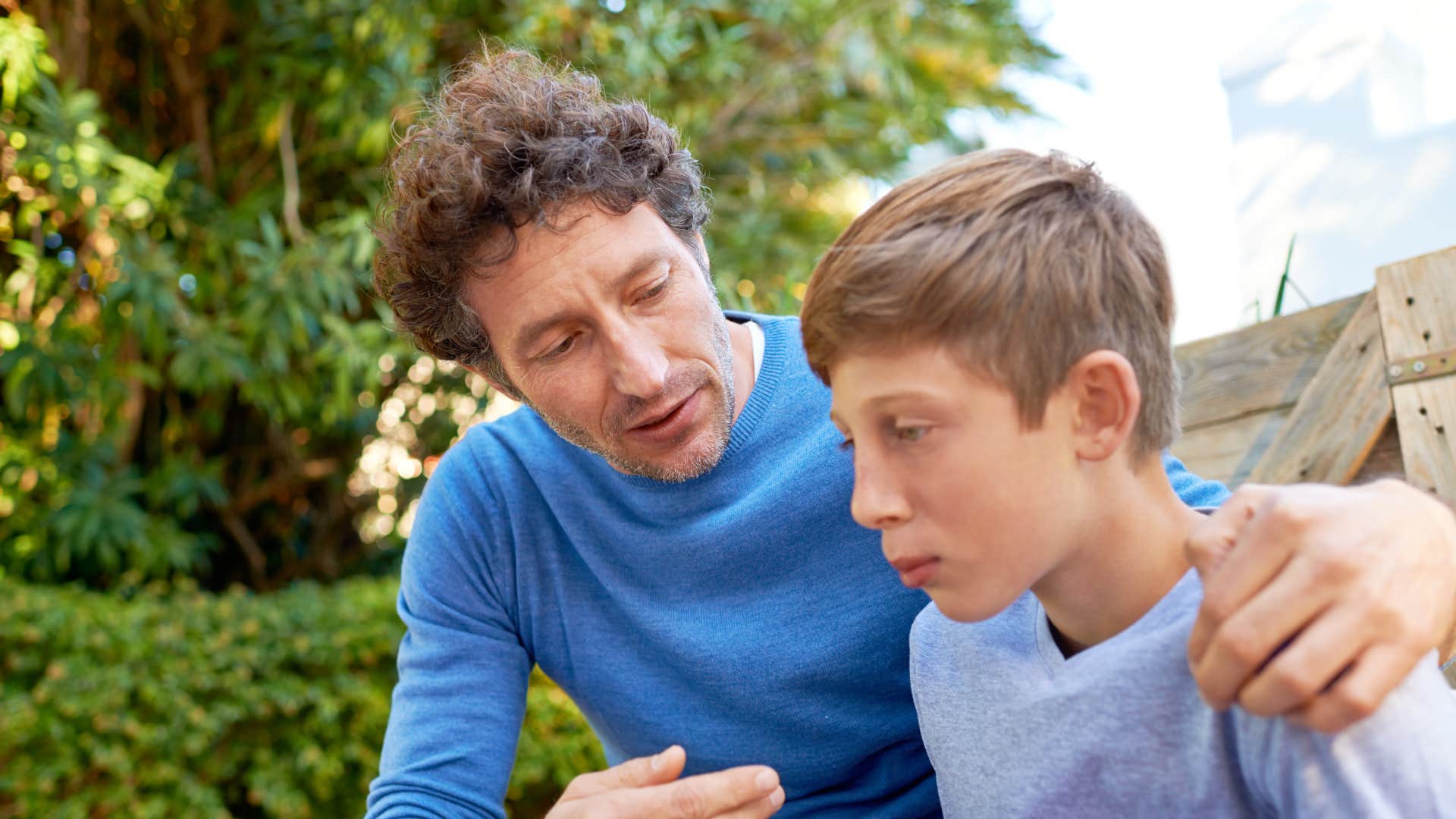 modern dad talking to teen son negotiating rules with him