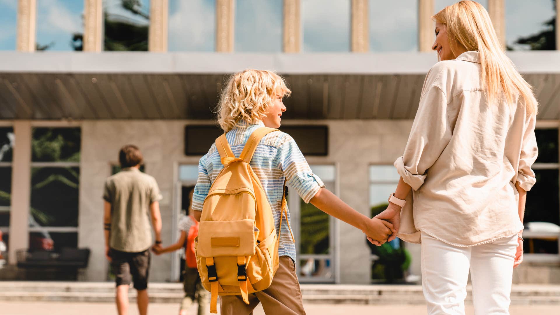 mom holding her son's hand shielding him from minor inconveniences