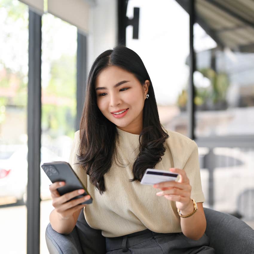 woman making purchase on smartphone using credit card this is a pattern to her spending