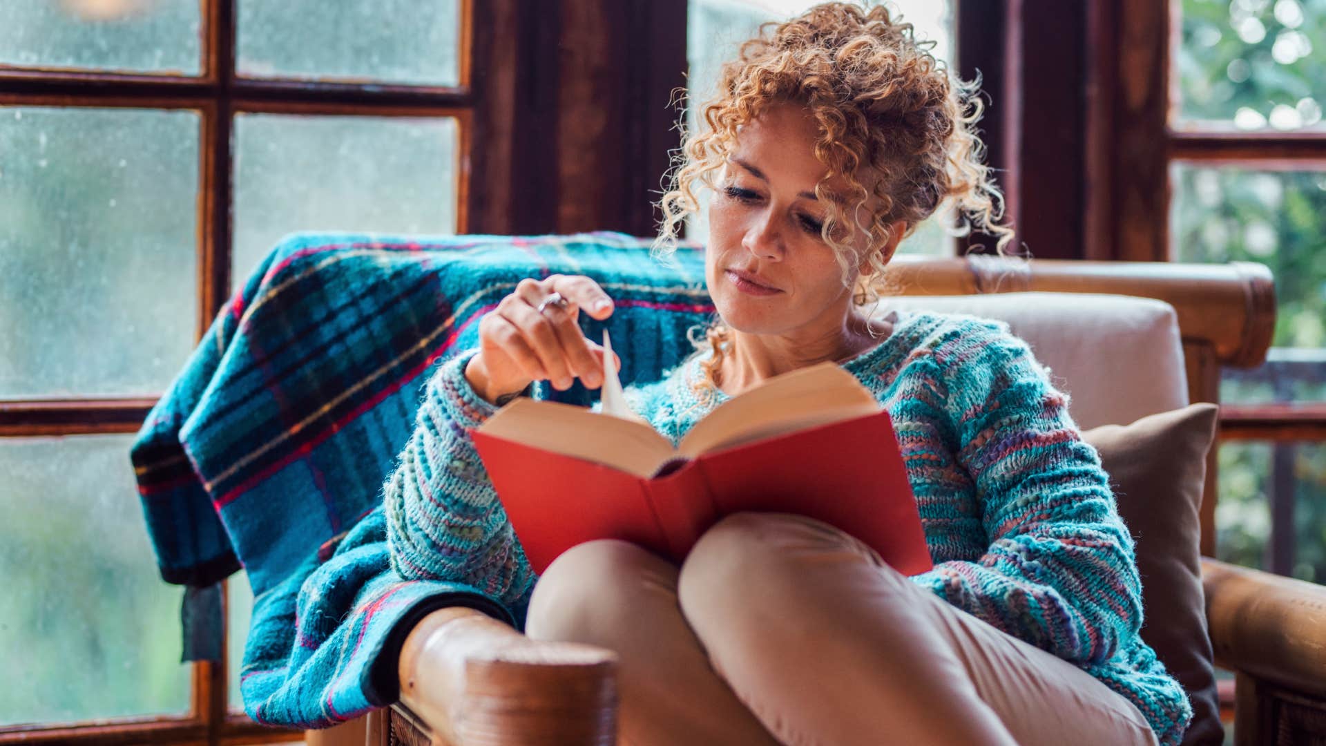 Woman who's comfortable with solitude reading at home.