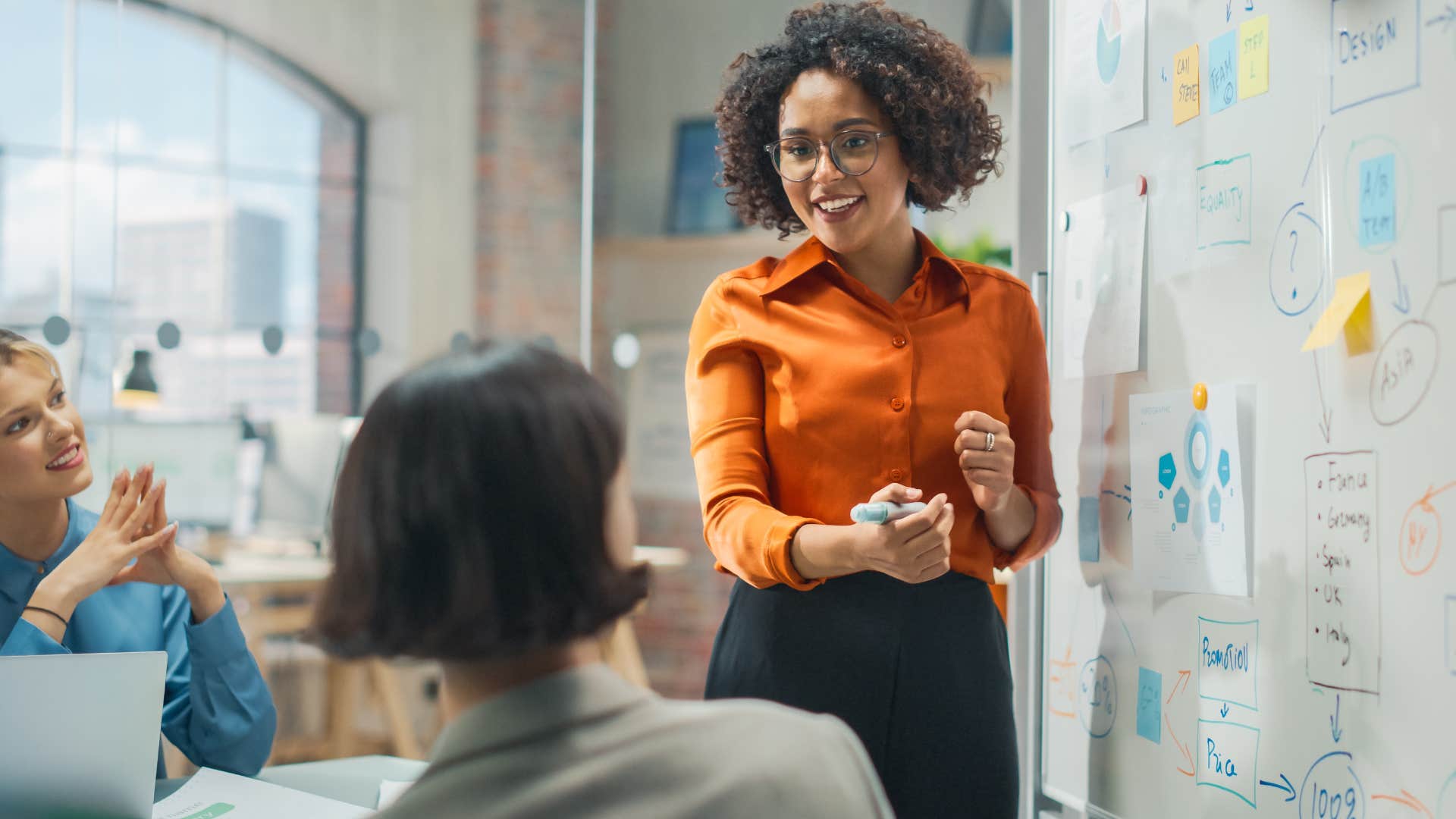 Woman who can read a room instantly talking in a meeting.