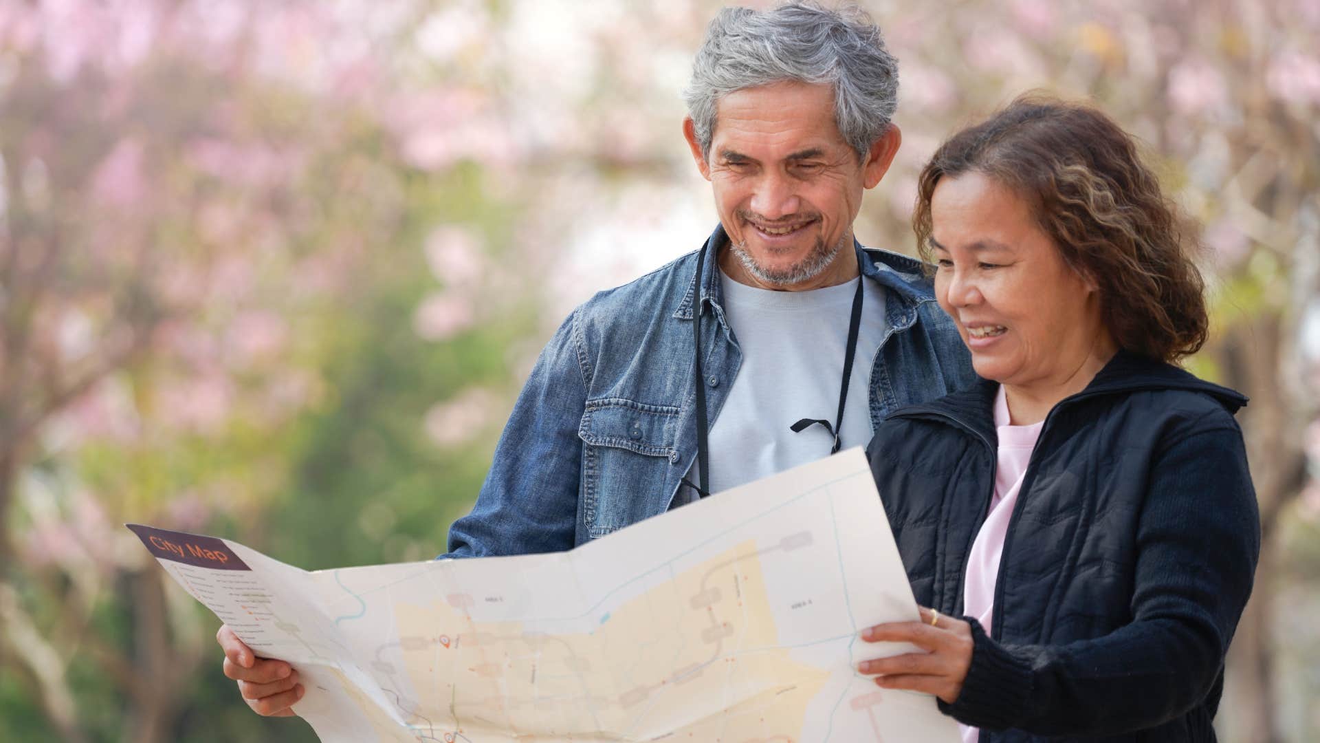 older couple navigating without GPS using physical map