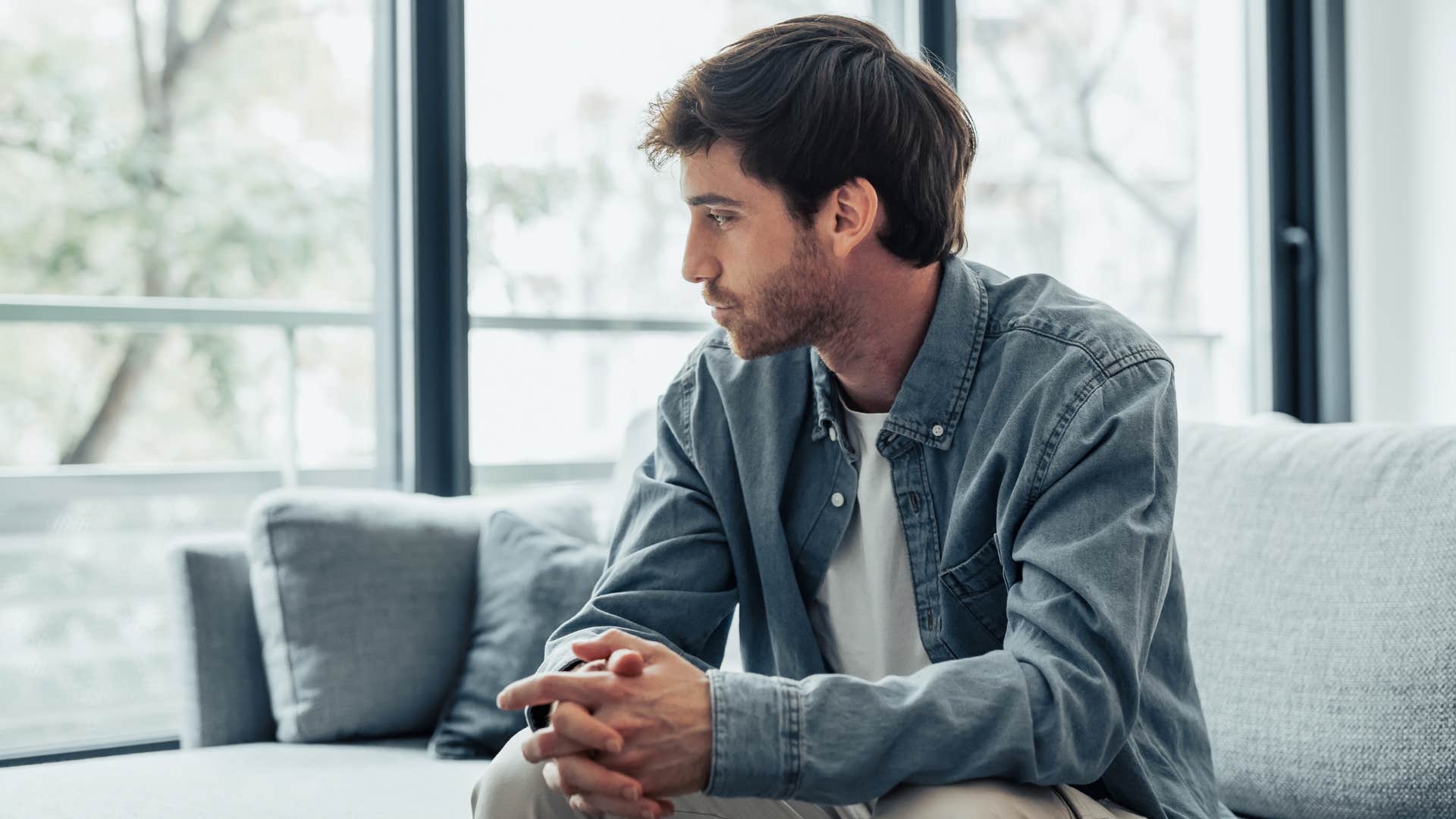 man reflecting on couch as social distancing has made younger generations like him more isolated