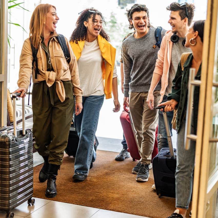 college students walking into airbnb with suitcases