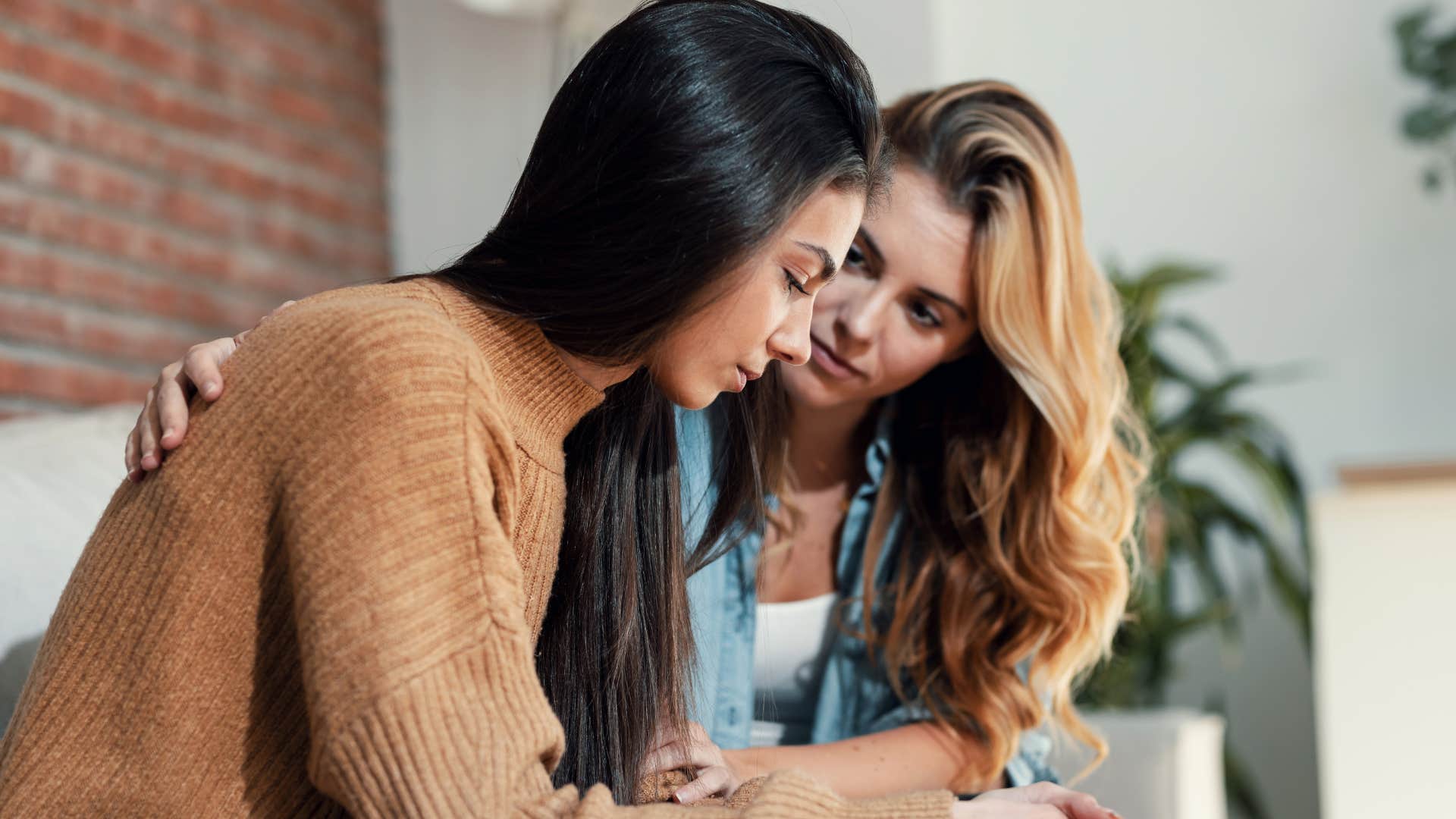 woman comforting friend as they observe more than they talk