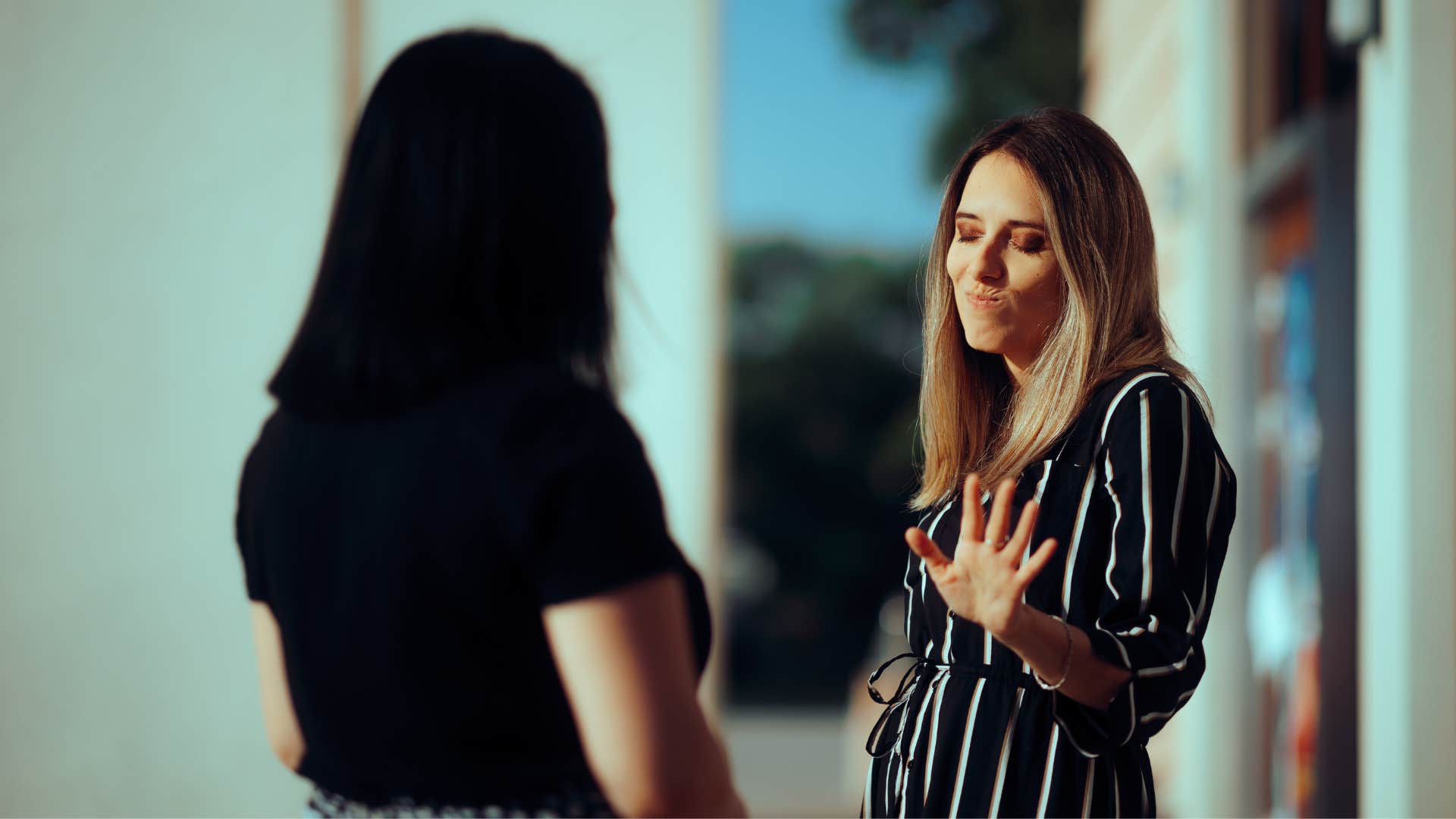 woman shrugging off woman in black dress as she trusts actions more than words