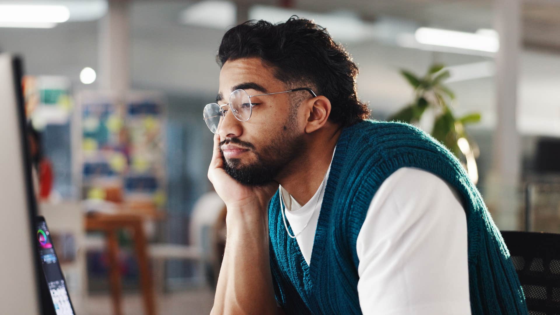 man looking bored at work procrastinating