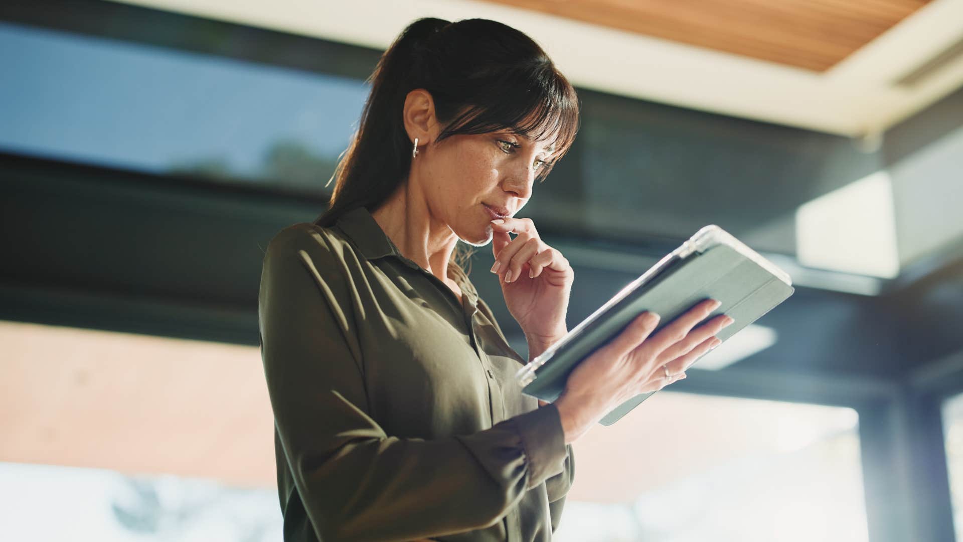 woman in green looking at tablet as she has good memory