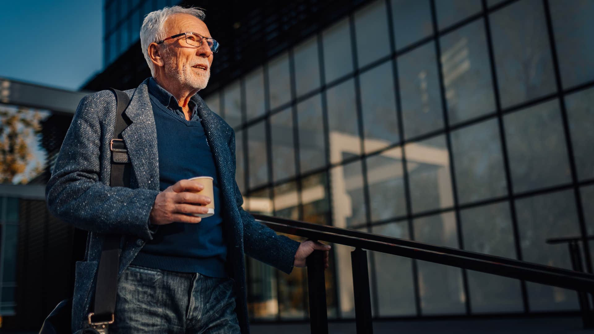 man with coffee going down the stairs as he has high confidence